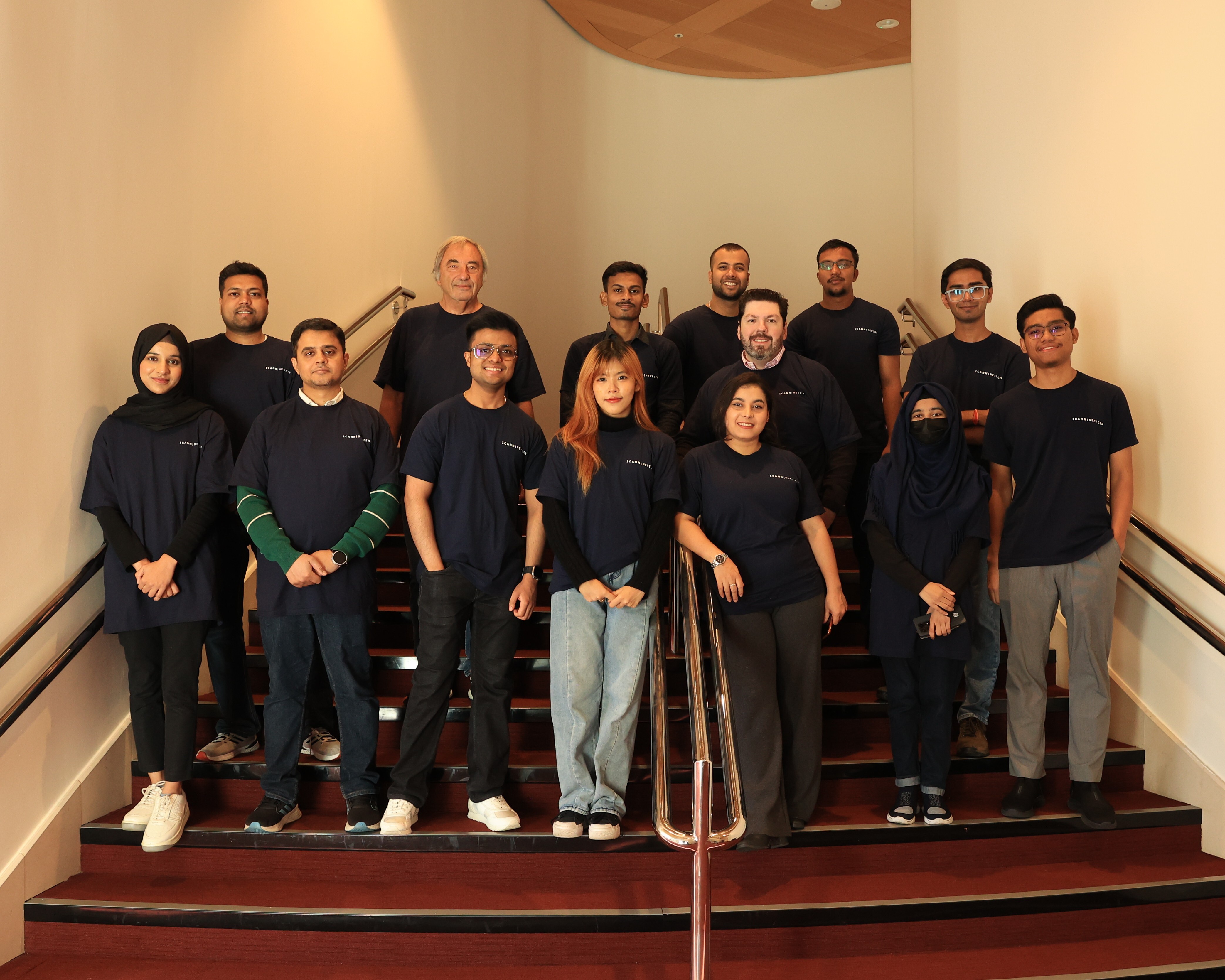 auDA staff member Saksham Jain standing with fellow NextGen@ICANN participants and mentors on a stairwell at ICANN84 in Dublin, Ireland.